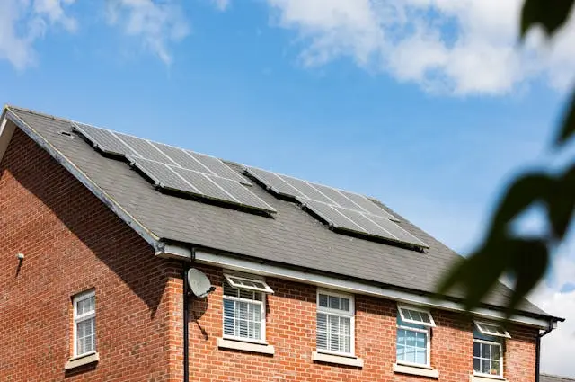 Brick house featuring solar panels on the roof promoting community energy.
